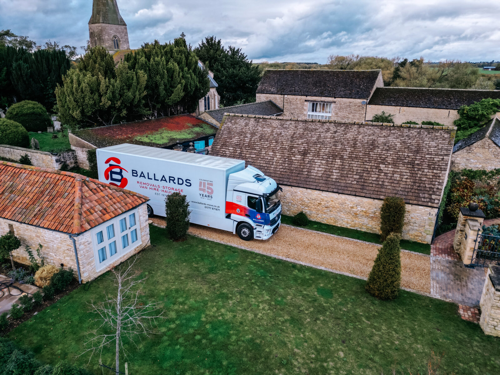 Ballards removals truck parked outside rural sandstone buildings